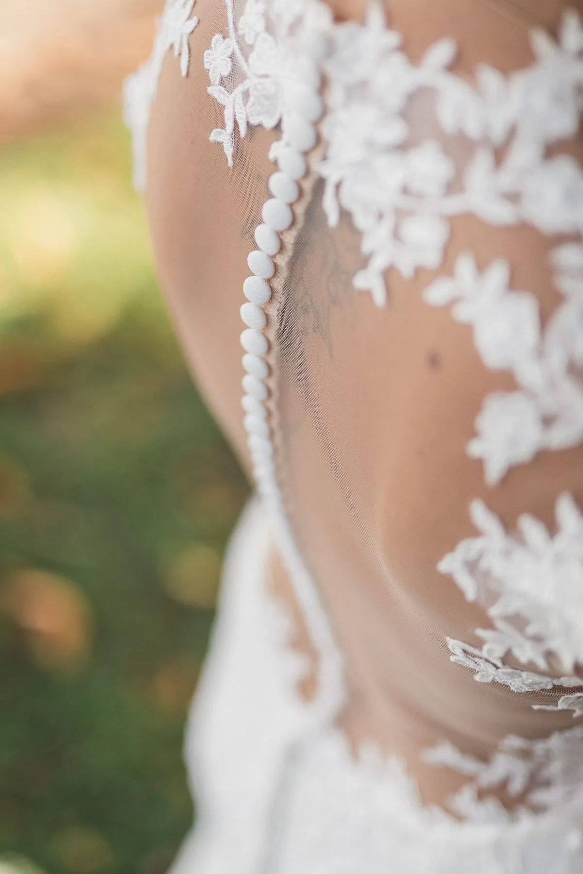 Zarte Spitze und feine Knöpfe an einem Brautkleid