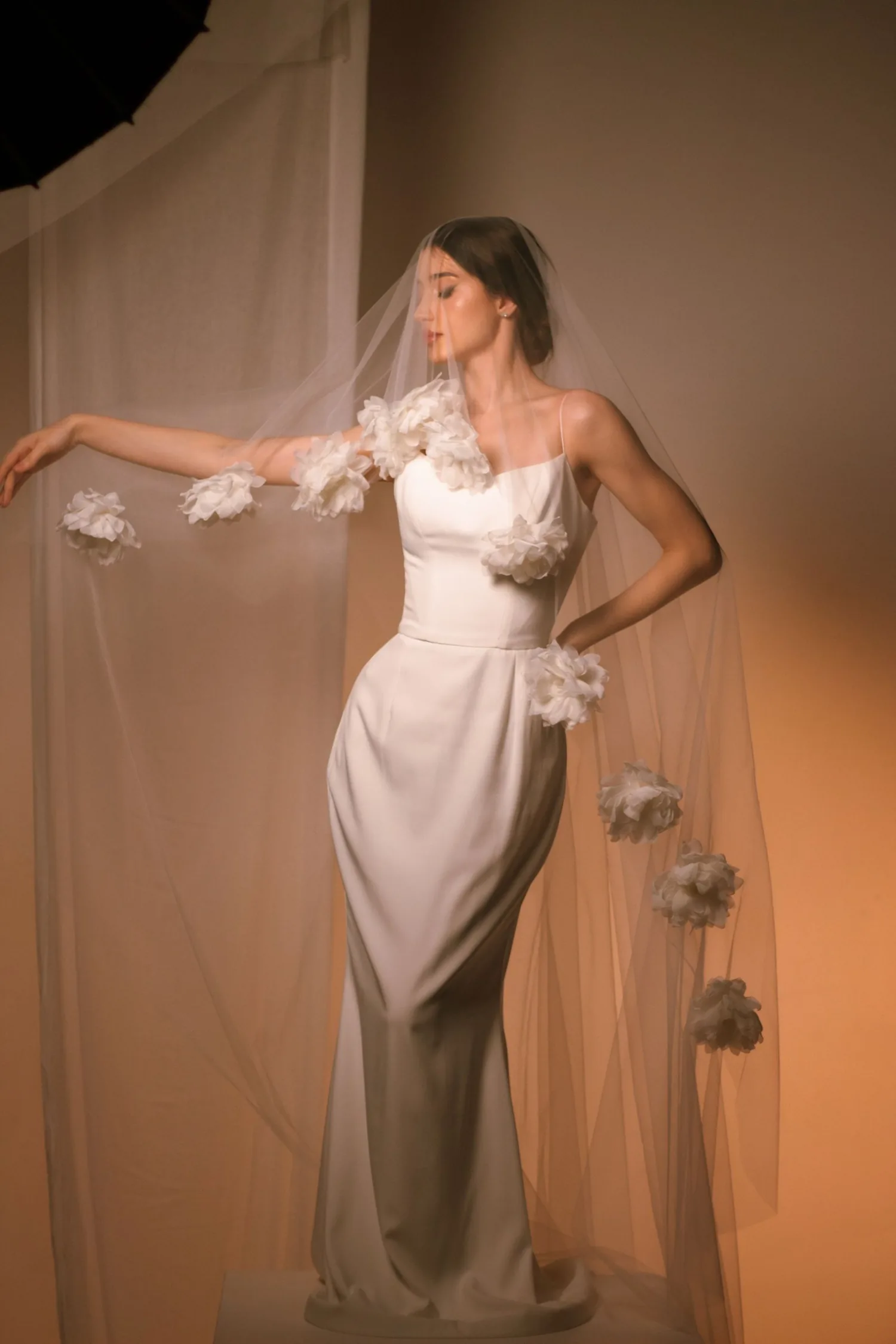 Brautmode-Inspiration: elegantes Brautkleid mit floralem Schleier in warmem Licht